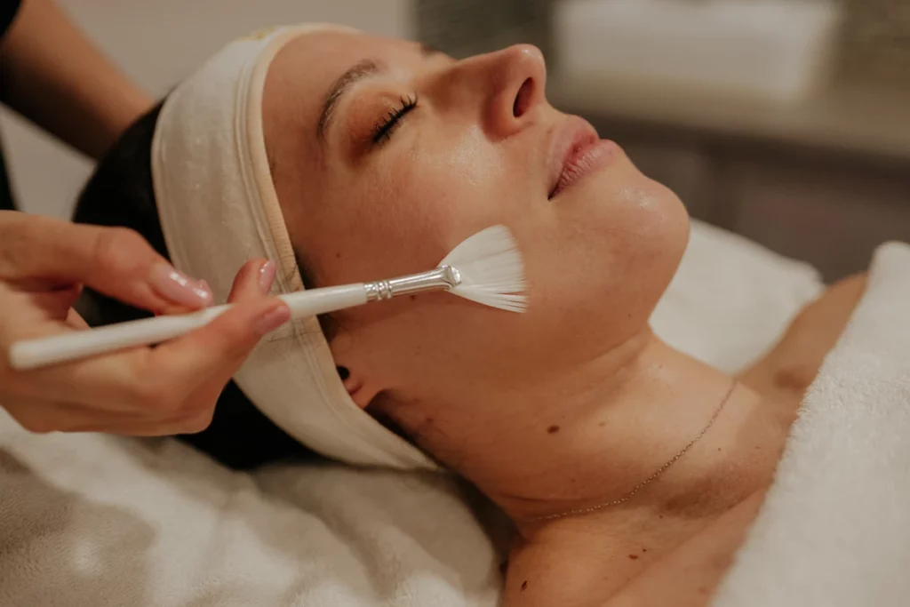 Application d’un soin du visage au pinceau en institut